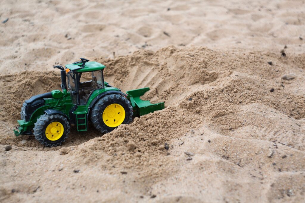 Een tractor in de zandbak.
